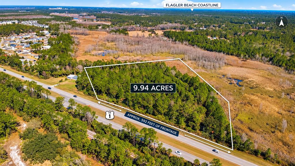 A paved road runs alongside a grassy shoulder with utility poles and a wooded area — US 1 NORTH, BUNNELL, FL