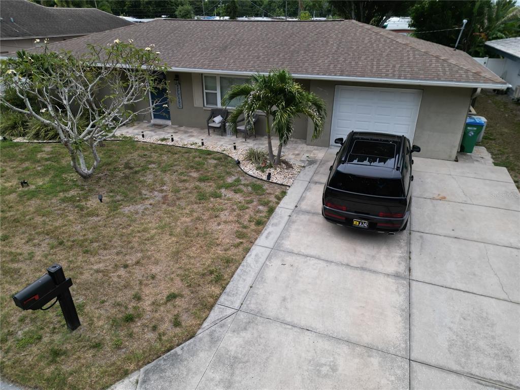 An aerial view shows a single-story house with a driveway, a black car, and landscaping — 10541 86TH AVENUE, SEMINOLE, FL