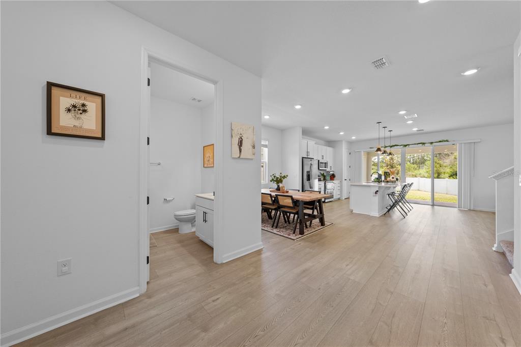 A view from a hallway into an open-concept kitchen, dining area, and living space — 4035 SOUTHERN VISTA LOOP, ST CLOUD, FL