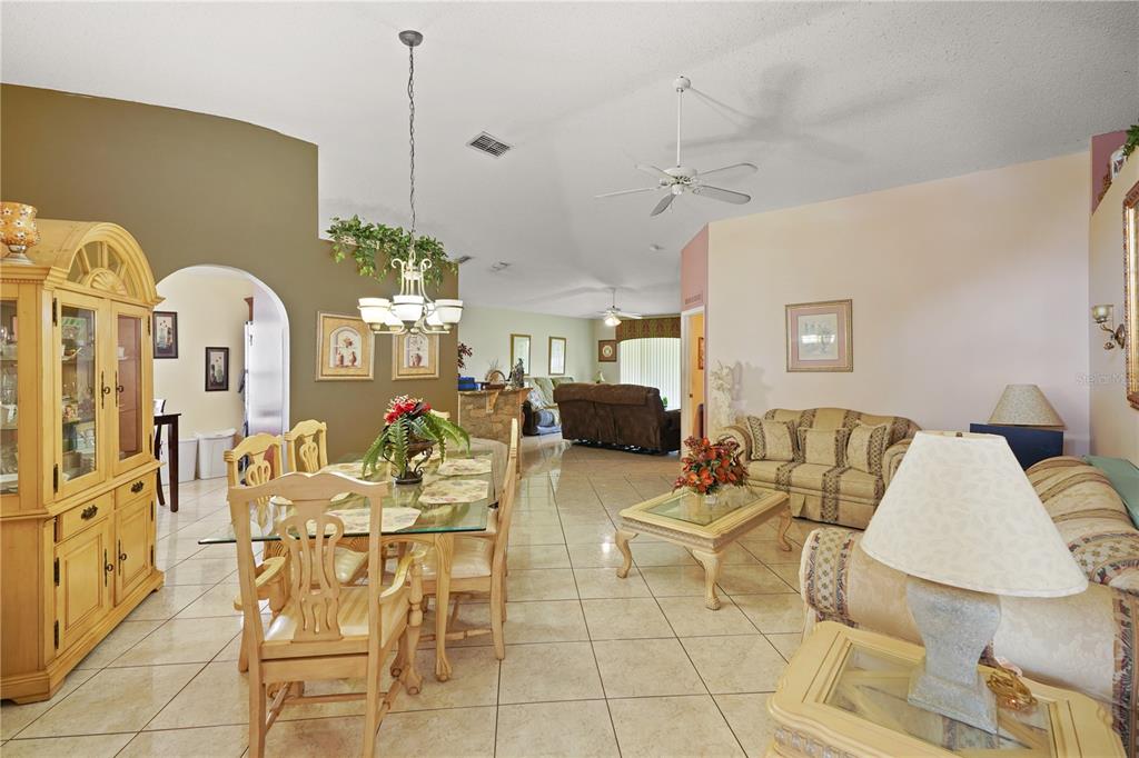 A living and dining room with tiled floors, vaulted ceilings, and a ceiling fan — 11545 BENTRY STREET, ORLANDO, FL