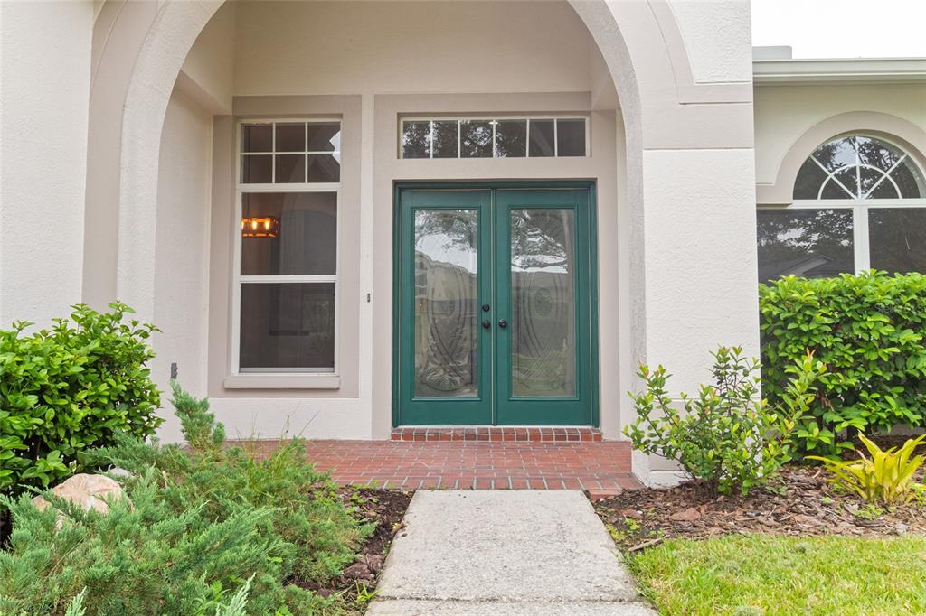 A front entryway features a green double door, a brick porch, and a concrete walkway — 10217 TIMBERLAND POINT DRIVE, TAMPA, FL