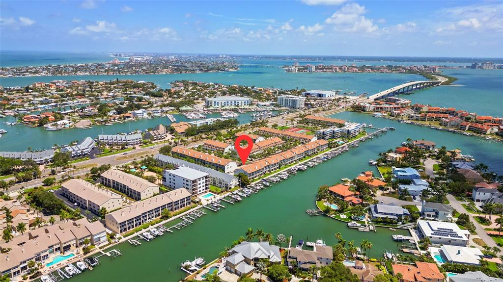 An aerial view shows a multi-story residential complex situated along a canal with boat slips — 367 MADEIRA CIRCLE, TIERRA VERDE, FL