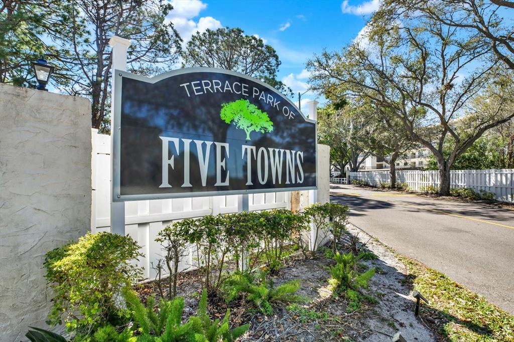A sign for Terrace Park of Five Towns stands beside a road and trees — 8186 TERRACE GARDEN DRIVE N UNIT 601, ST PETERSBURG, FL