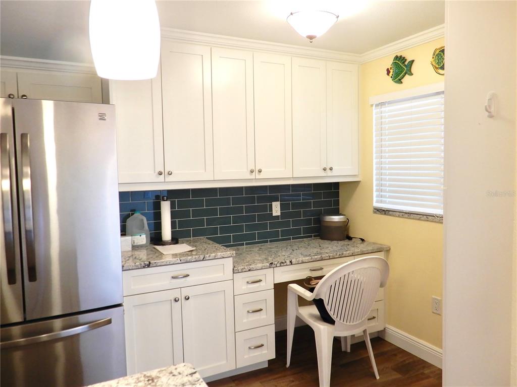 A bathroom features a white toilet, a glass-enclosed shower, and a tall white storage cabinet — 103 1ST STREET E UNIT 210, TIERRA VERDE, FL