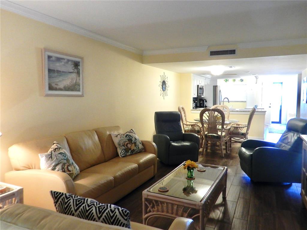 A living room with a leather sofa, two recliners, and a glass-topped coffee table — 103 1ST STREET E UNIT 210, TIERRA VERDE, FL