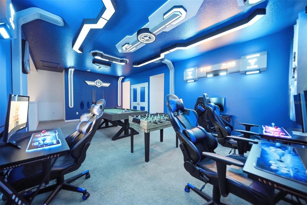 A blue-themed game room features multiple gaming chairs, a pool table, and a foosball table — 2532 SHANTI DRIVE, KISSIMMEE, FL