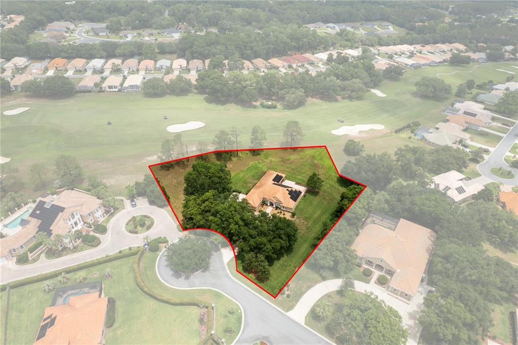 An aerial view shows a house with a solar-paneled roof on a large, landscaped lot — 1969 N YAWKEY POINT, HERNANDO, FL