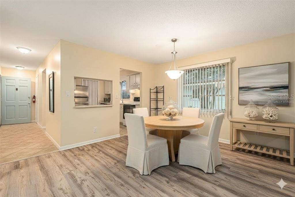 A dining room with a round table, four chairs, and light wood-look flooring — 11200 102ND AVENUE UNIT 16, SEMINOLE, FL
