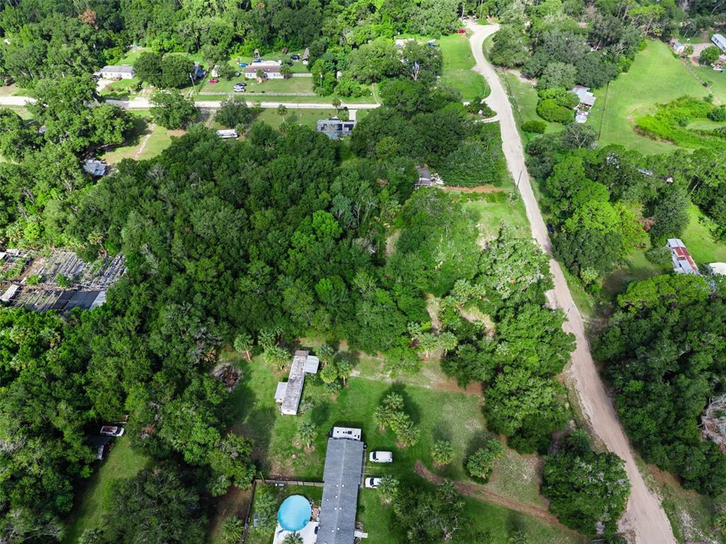 An aerial view shows a rural property with a house, pool, and surrounding wooded land — 22308 HORIZON VISTAS DRIVE, EUSTIS, FL