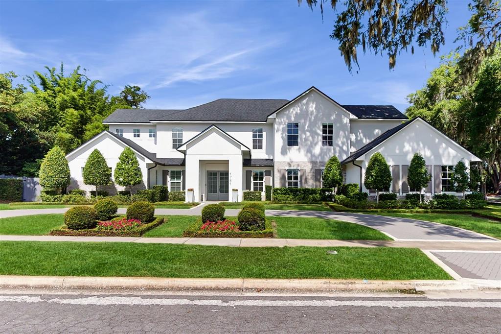 A large two-story white house with a dark roof and manicured landscaping — 1761 LEGION DRIVE, WINTER PARK, FL