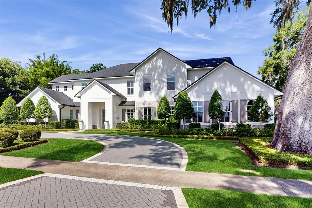 A two-story white house with a dark roof and a paved circular driveway — 1761 LEGION DRIVE, WINTER PARK, FL