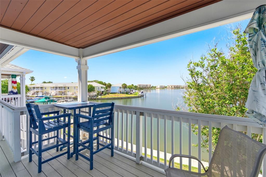 An aerial view shows a light blue multi-story building with a parking lot and waterfront — 4805 COBIA DRIVE SE UNIT D Furnished, ST PETERSBURG, FL