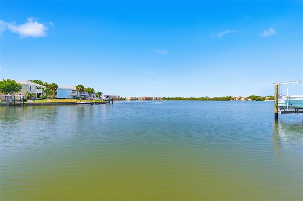 A view of a calm waterway with houses on the left and a boat lift — 4805 COBIA DRIVE SE UNIT D Furnished, ST PETERSBURG, FL