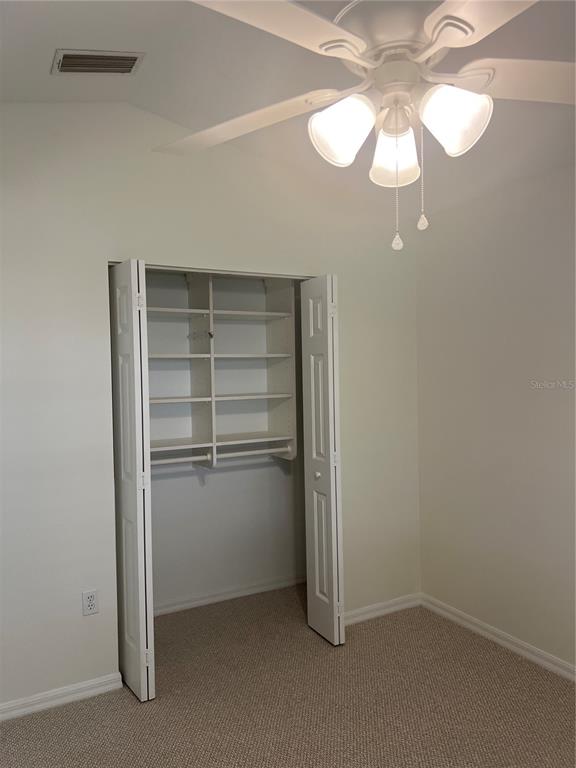 A single-story house with a white garage, arched entryway, and a large tree in front — 6381 EGRET DRIVE UNIT 14, LAKELAND, FL