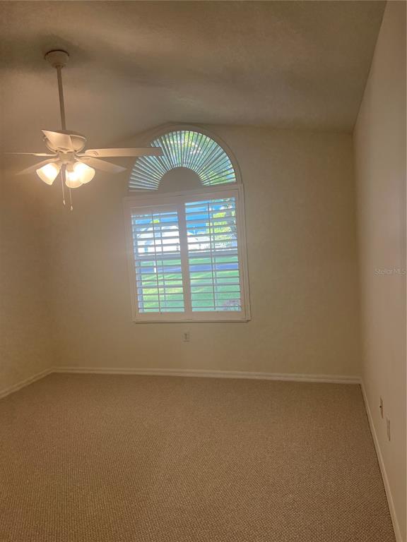 A concrete walkway leads to an arched entryway with a gray double door — 6381 EGRET DRIVE UNIT 14, LAKELAND, FL