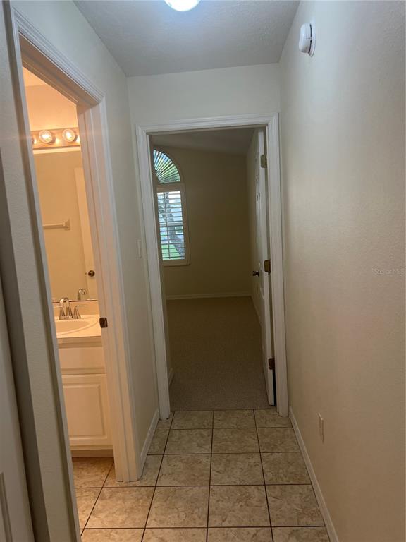 A kitchen features white cabinets, white appliances, and light-colored tile flooring — 6381 EGRET DRIVE UNIT 14, LAKELAND, FL