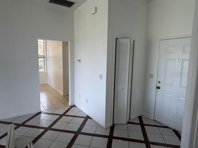 An entryway with white walls, a tiled floor with a grid pattern, and a closet door — 4633 HAZELGROVE DRIVE, ORLANDO, FL