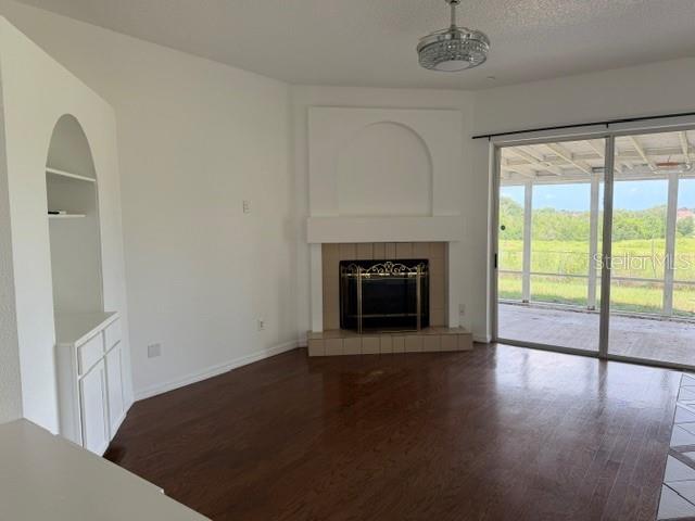 A living room with hardwood floors, a fireplace, built-in shelving, and a sliding glass door — 4633 HAZELGROVE DRIVE, ORLANDO, FL