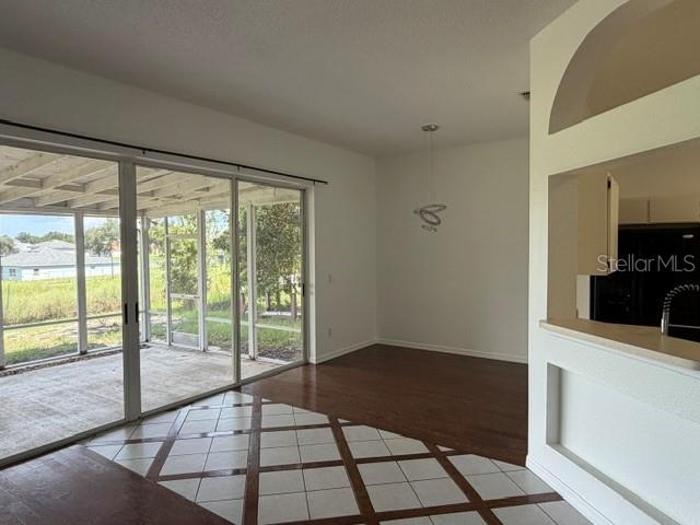 A dining area features a tiled floor with wood accents, sliding glass doors, and a pass-through — 4633 HAZELGROVE DRIVE, ORLANDO, FL