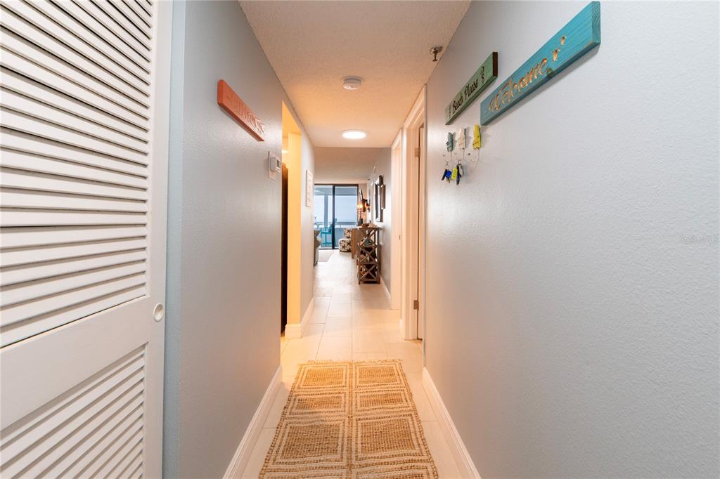 A living room features a light blue sofa, a wooden coffee table, and a balcony view — 17900 GULF BOULEVARD UNIT 11C, REDINGTON SHORES, FL