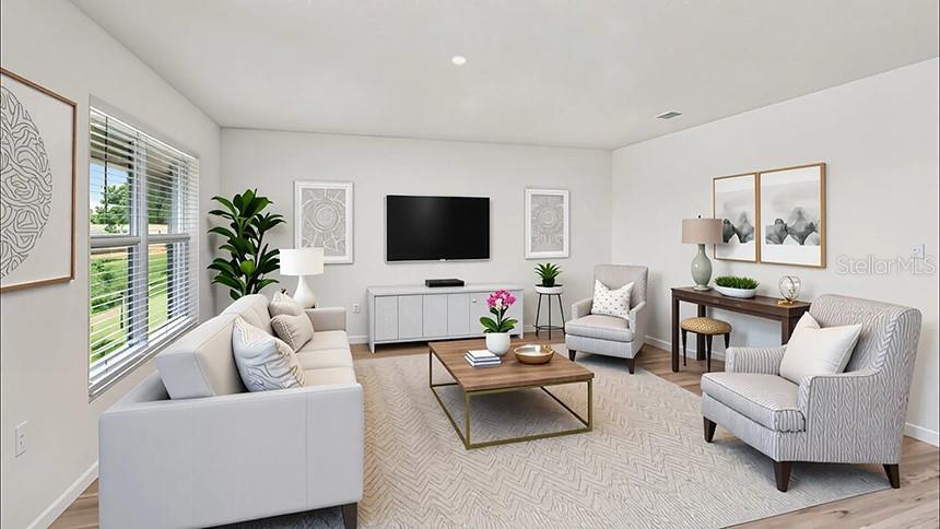 This is a digital rendering of a living room with neutral furniture and a television — 8782 TRIUMPH CIRCLE, WILDWOOD, FL