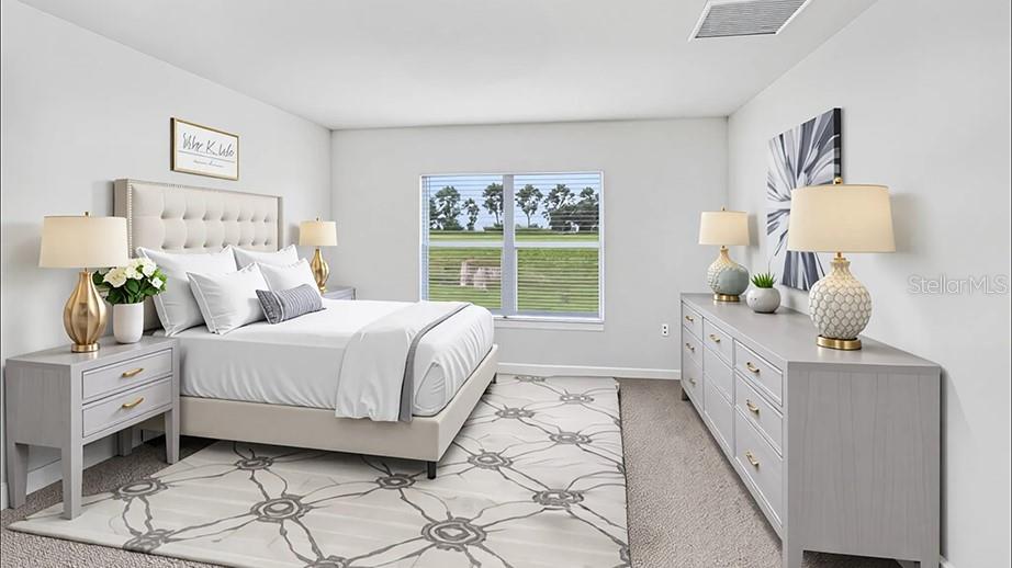 A bedroom features a tufted headboard, a gray dresser, and a window overlooking a grassy field — 8782 TRIUMPH CIRCLE, WILDWOOD, FL