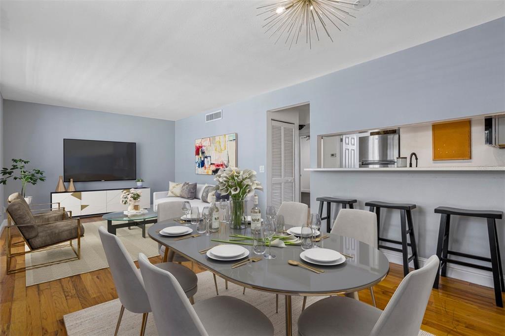 A dining area with a grey oval table sits in front of an open-concept kitchen — 1301 S HOWARD AVENUE UNIT C18, TAMPA, FL