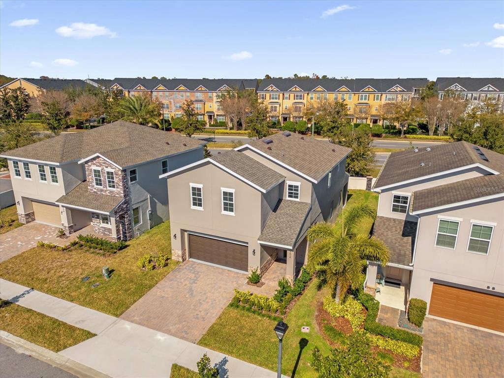 An aerial view shows three suburban houses with paved driveways and a multi-unit building behind — 1252 ASH TREE COVE, CASSELBERRY, FL