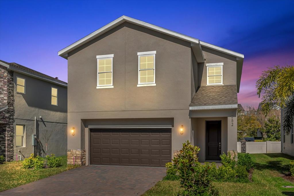 A two-story house with a brown garage, gray stucco exterior, and a paved driveway — 1252 ASH TREE COVE, CASSELBERRY, FL