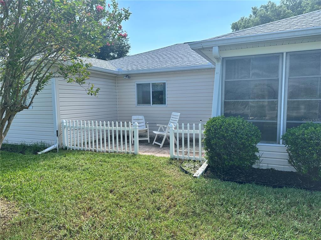 A small patio with white fencing sits beside a house with light-colored vinyl siding — 13780 SW 115TH CIRCLE, DUNNELLON, FL
