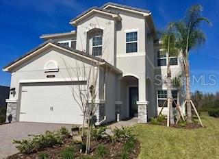 A two-story house with a beige stucco exterior, a two-car garage, and two palm trees — 30791 LINDENTREE DRIVE, WESLEY CHAPEL, FL
