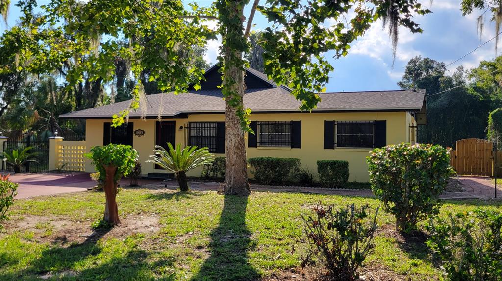 A yellow single-story house with a dark roof and security bars on the windows — 1014 SE 10TH STREET, GAINESVILLE, FL