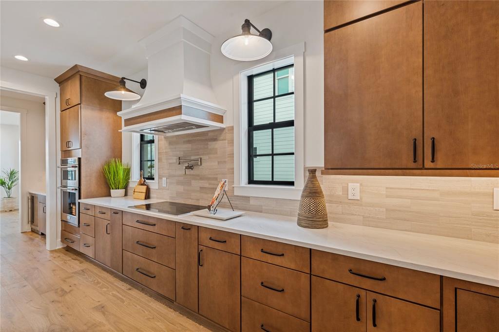 A bright living and dining area features white walls, hardwood floors, and large windows — 220 90TH AVENUE NE, ST PETERSBURG, FL