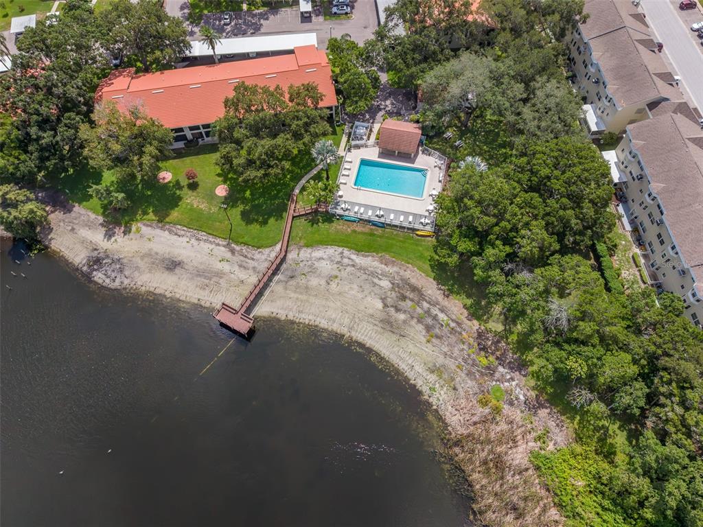 An aerial view shows a building with a red roof, a swimming pool, and a dock — 2022 NASH DRIVE, CLEARWATER, FL