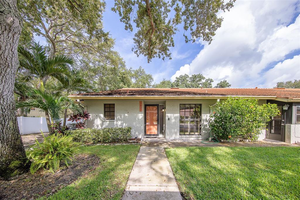 A single-story house with a light-colored exterior, a red front door, and a concrete walkway — 2022 NASH DRIVE, CLEARWATER, FL
