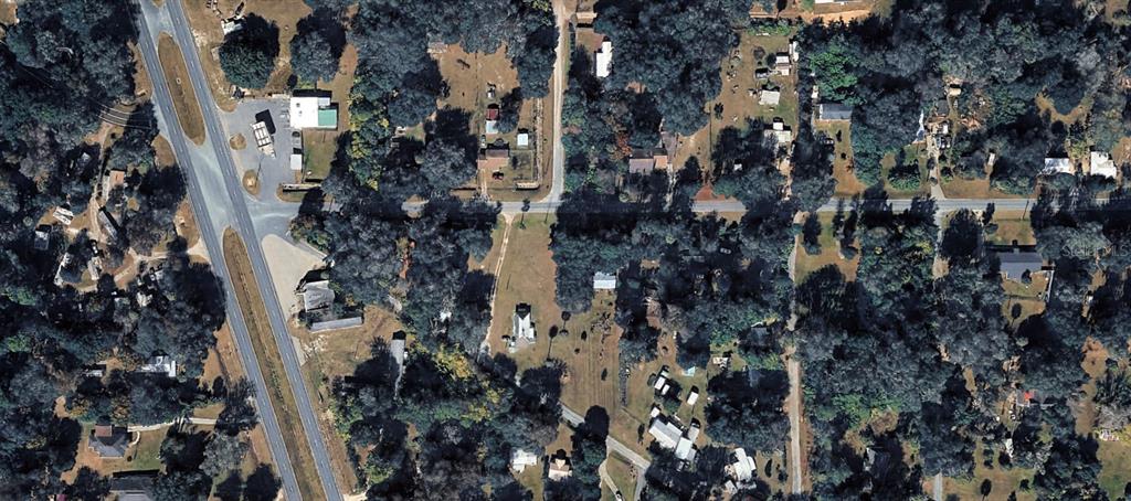 This aerial view shows a rural residential area with scattered houses, trees, and paved roads — XX NW 191ST LN ROAD, REDDICK, FL