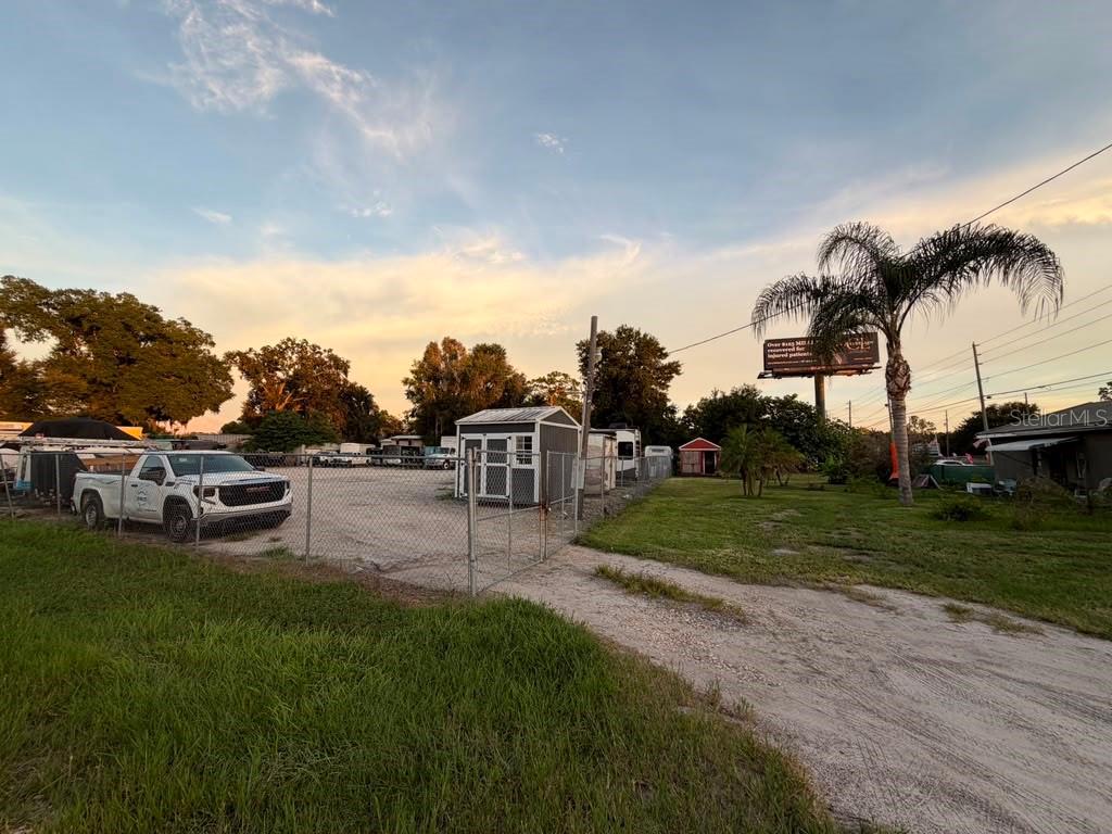 A gravel lot with a white pickup truck, a small shed, and a chain-link fence — 6012 LAND O LAKES BOULEVARD, LAND O LAKES, FL