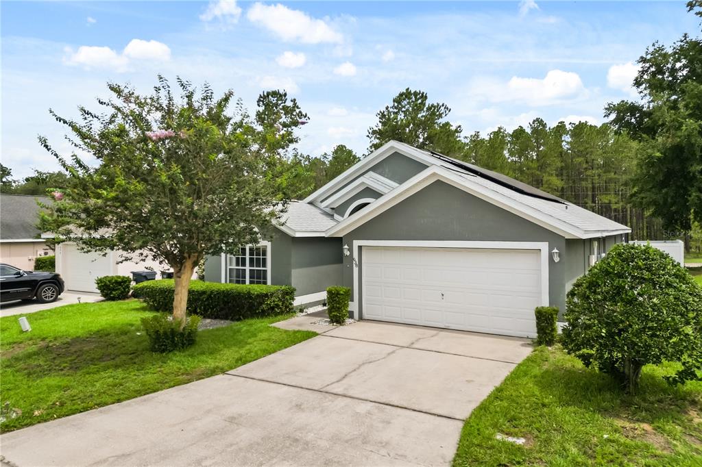 A gray single-story house with a white garage door and a concrete driveway — 638 PINE CONE DRIVE, DAVENPORT, FL