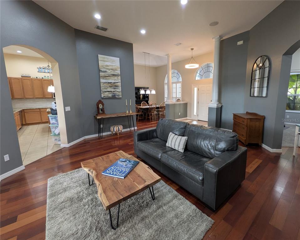 A living room with dark gray walls, hardwood floors, a leather sofa, and a coffee table — 920 SAZA RUN, CASSELBERRY, FL