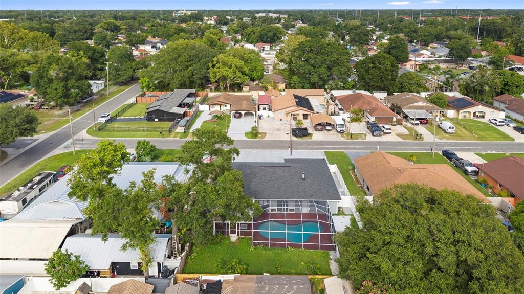 An aerial view shows a residential house with a screened-in pool and a large backyard — 6920 N CAMERON AVENUE, TAMPA, FL