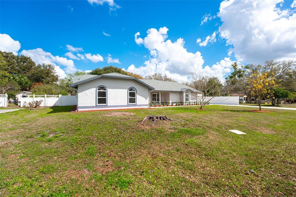 A single-story house with a light-colored exterior and arched windows sits on a grassy lot — 5521 OAK STREET, MOUNT DORA, FL