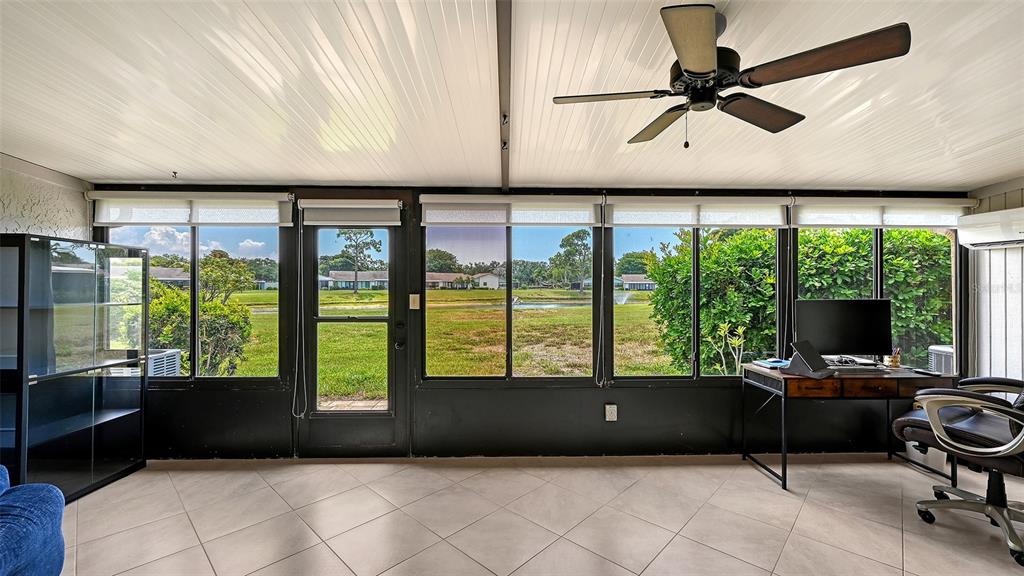 An aerial view shows a residential community with single-story buildings, a central pond, and landscaping — 6129 HERITAGE LANE W UNIT 6129, BRADENTON, FL