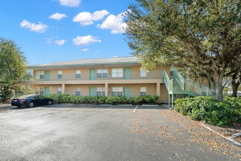 A two-story apartment building with a metal roof, exterior walkways, and a parking lot — 5816 CONGRESS STREET UNIT 203, NEW PORT RICHEY, FL