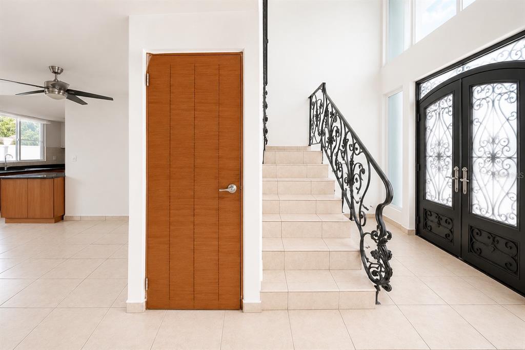 An entryway features a tiled staircase with a decorative iron railing and an under-stair closet — Estancias de Cerro Gordo N CALLE NINOSHKA UNIT B-12, VEGA ALTA, PR