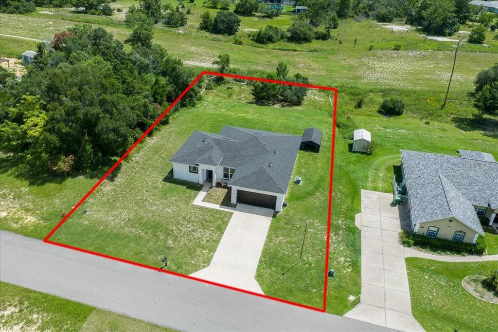 An aerial view shows a single-story house with a driveway and yard outlined in red — 16373 SW 48TH CIRCLE, OCALA, FL