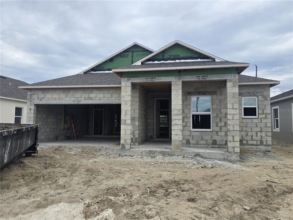 An open-concept kitchen and living area featuring dark cabinetry, a large island, and wood-look flooring — 6466 CHORUS DRIVE, MASCOTTE, FL