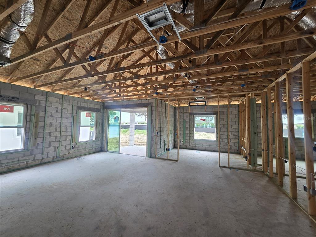 A modern kitchen features dark wood cabinets, granite countertops, a center island, and wood-look flooring — 6466 CHORUS DRIVE, MASCOTTE, FL