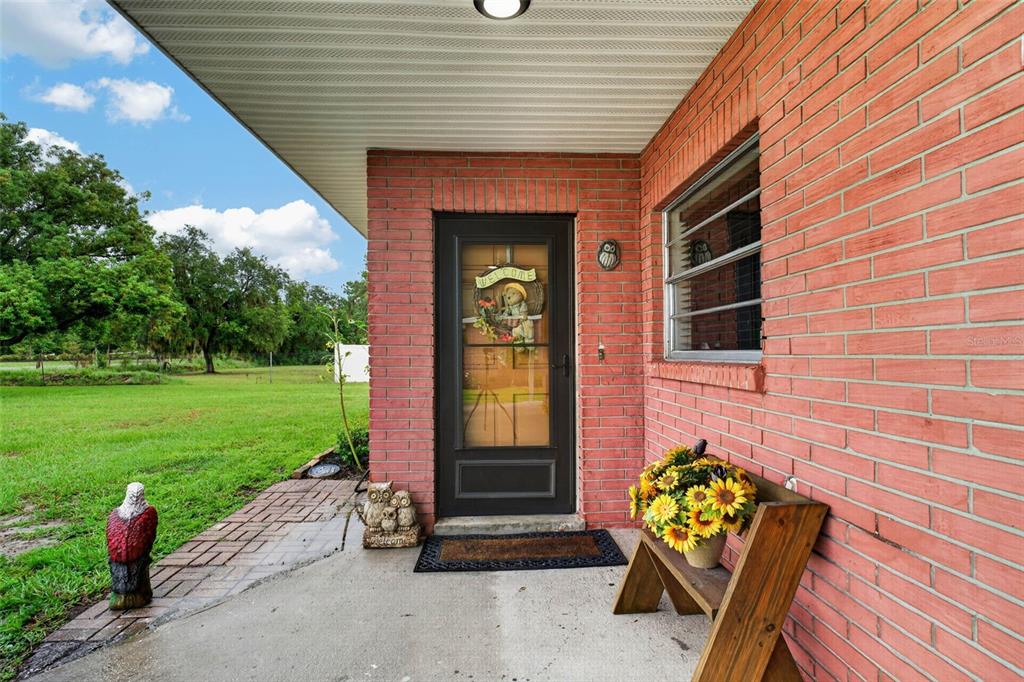A single-story red brick house with a steep roof, attached carport, and a front lawn — 5838 OLD BARTOW EAGLE LAKE ROAD, WINTER HAVEN, FL