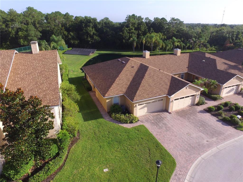 An aerial view shows two suburban houses with brown shingled roofs and paved driveways — 1307 INNSBRUCK CT, WINTER HAVEN, FL