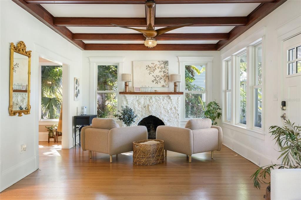A living room features a white stone fireplace, coffered wood ceiling, and two beige armchairs — 1473 BARCELONA AVENUE, FORT MYERS, FL